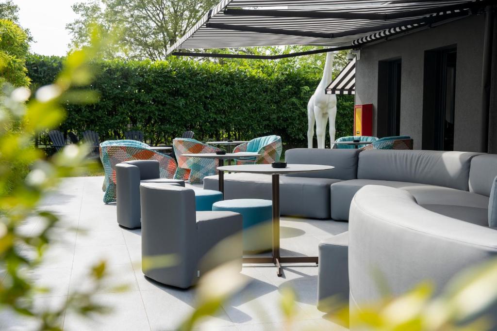 a patio with couches and a table and chairs at The Aries Hotel in Vicenza