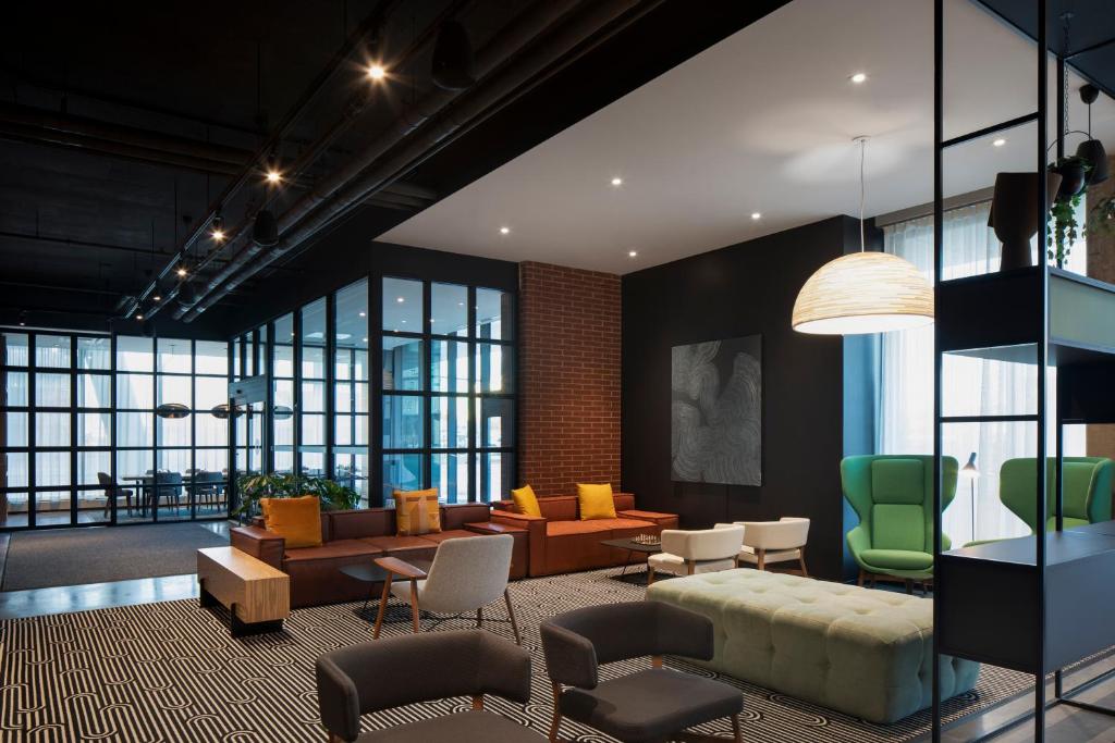 a living room with a couch and chairs at Alt Hotel Calgary University District in Calgary