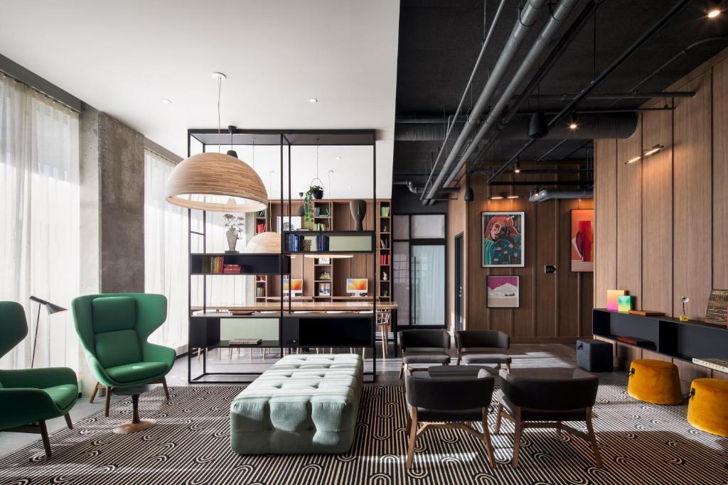 a living room with green chairs and a couch at Alt Hotel Calgary University District in Calgary