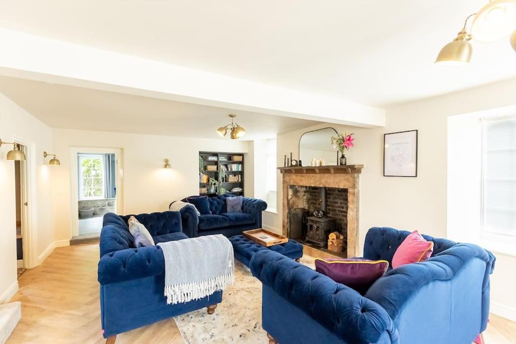 a living room with blue couches and a fireplace at OLD BANK HOUSE - Perfect Getaway for Friends & Families in Holker