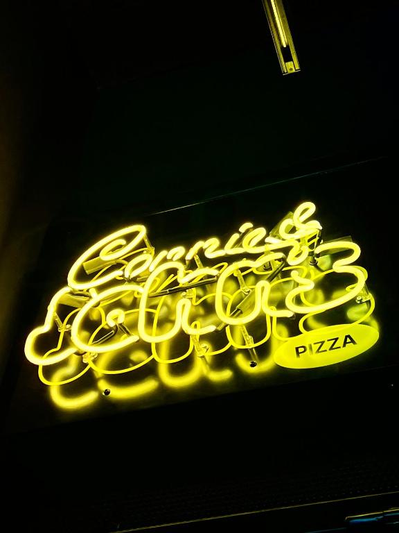 a neon sign that says pizza on a wall at Alt Hotel Calgary University District in Calgary