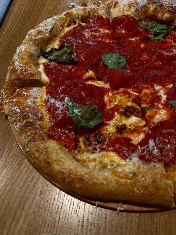 a pizza sitting on top of a wooden table at Alt Hotel Calgary University District in Calgary