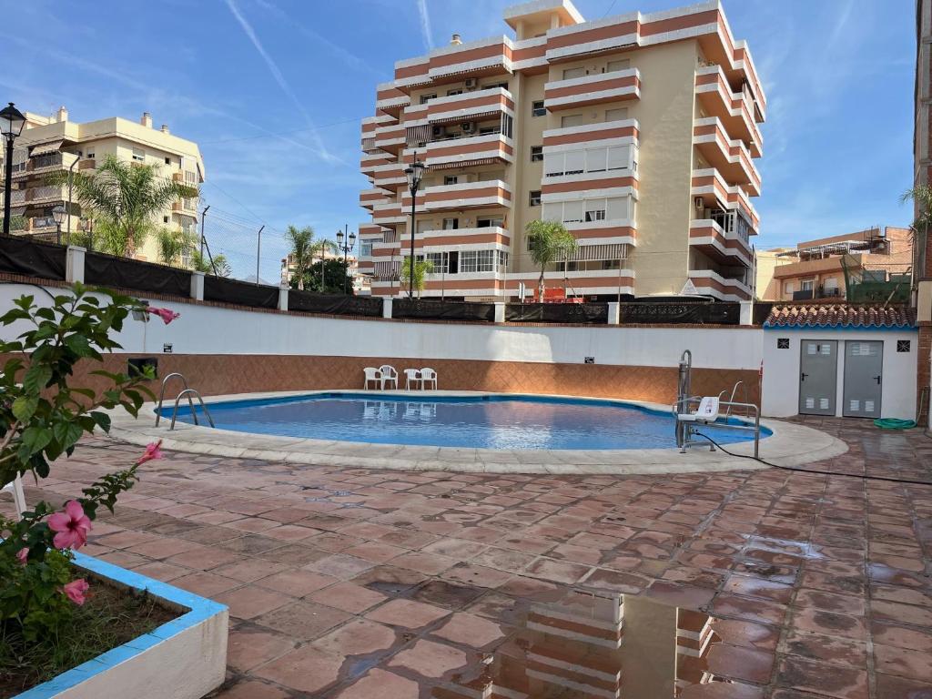a swimming pool in front of a apartment building at CT 301 - Faro's Fuengirola Centro Studio in Fuengirola