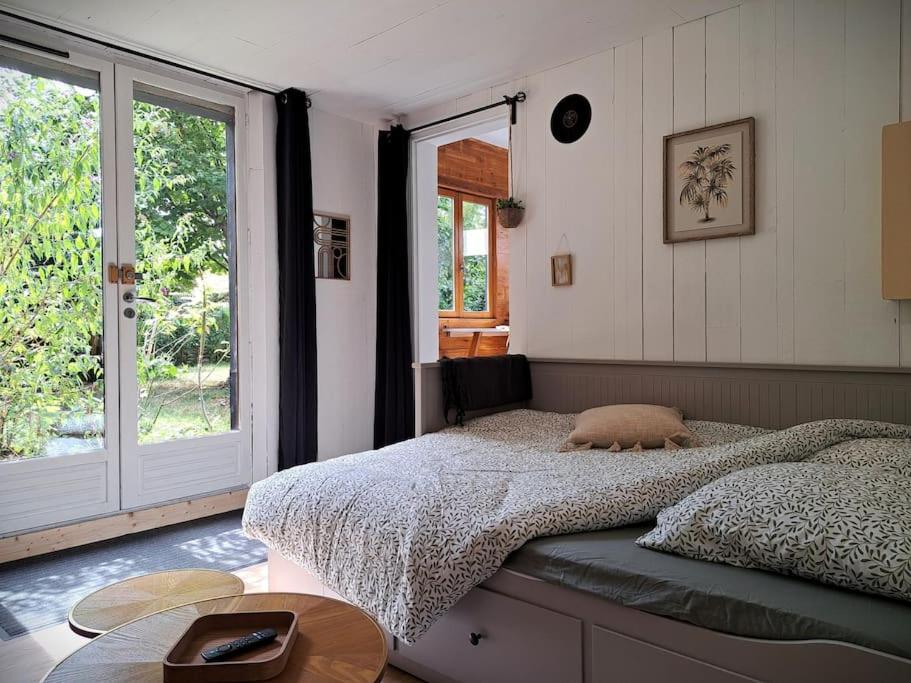 une chambre avec un lit et une grande fenêtre dans l'établissement La Cabane des Dunes, à Poitiers