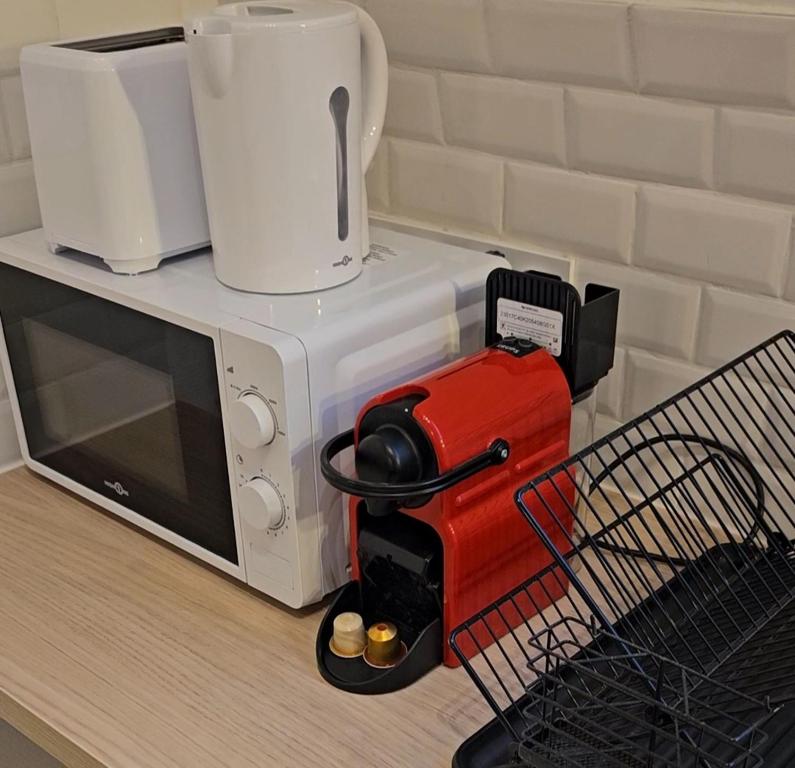 - un four micro-ondes au-dessus d'un comptoir avec une cafetière dans l'établissement Brun noisetier, à Tourcoing