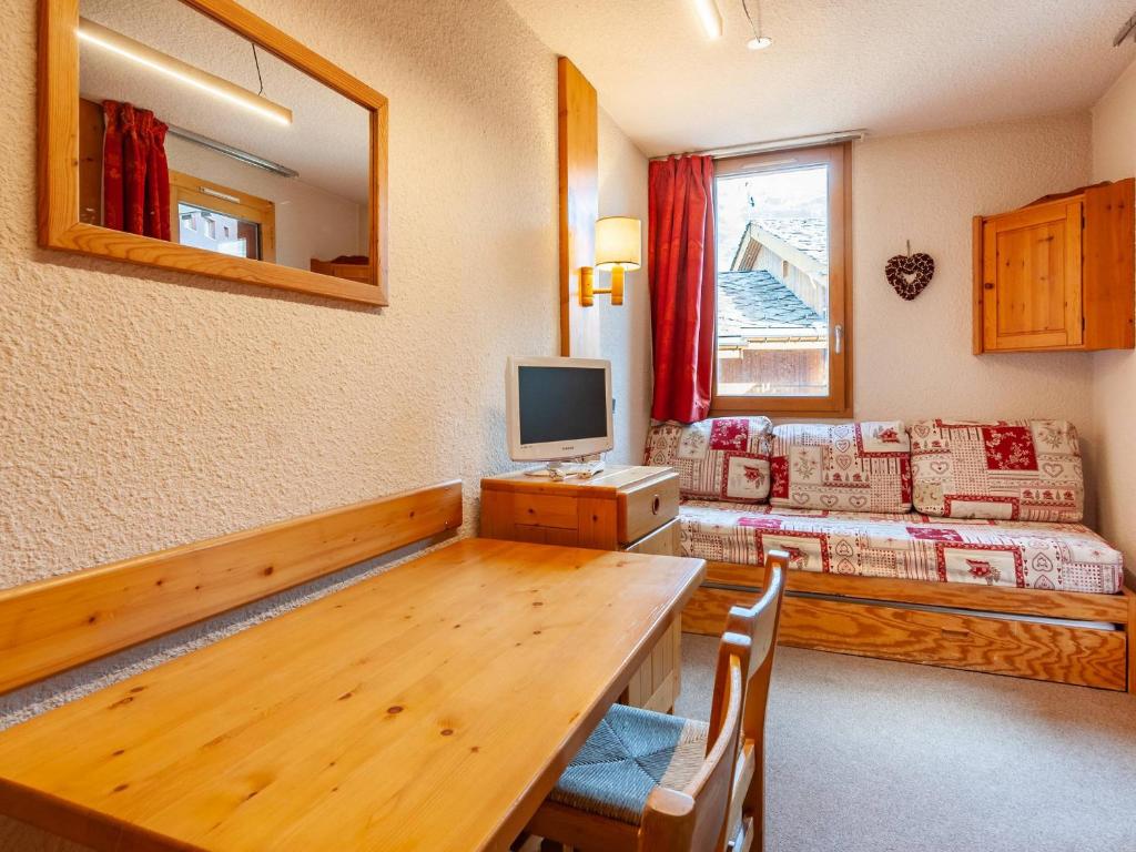 un salon avec une table et une télévision dans l'établissement Studio ski-in/ski-out, balcon, divisible, Laitelet - FR-1-355-26, à Méribel