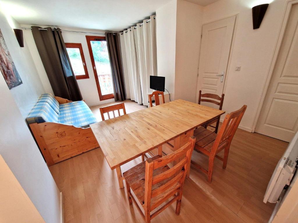 une salle à manger avec une table et des chaises en bois dans l'établissement Charmant 2 pièces avec coin montagne, 4/6 personnes, 32 m², balcon sud, à Modane - FR-1-265-247, à Valfréjus