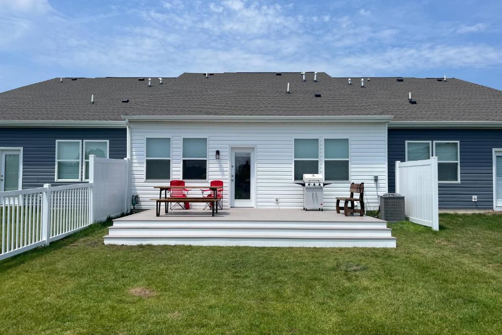 a house with a deck with two chairs and a picnic table at Millville by the Sea --- 35015 Sunfish Ln in Millville