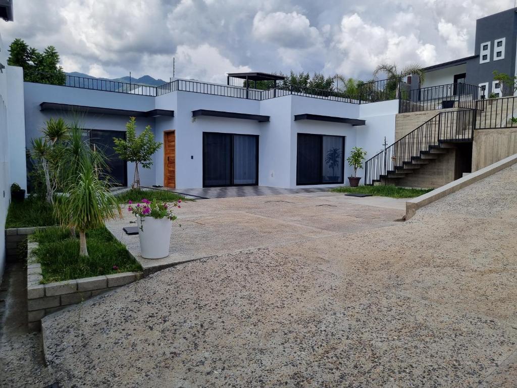 a white house with a driveway and stairs at Casa Golondrinas Huayápam in San Andrés Huayapan