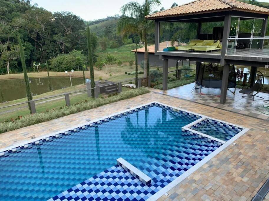 ein Swimmingpool vor einem Haus in der Unterkunft Rancho em Nazaré Paulista, Brasil in Quadra