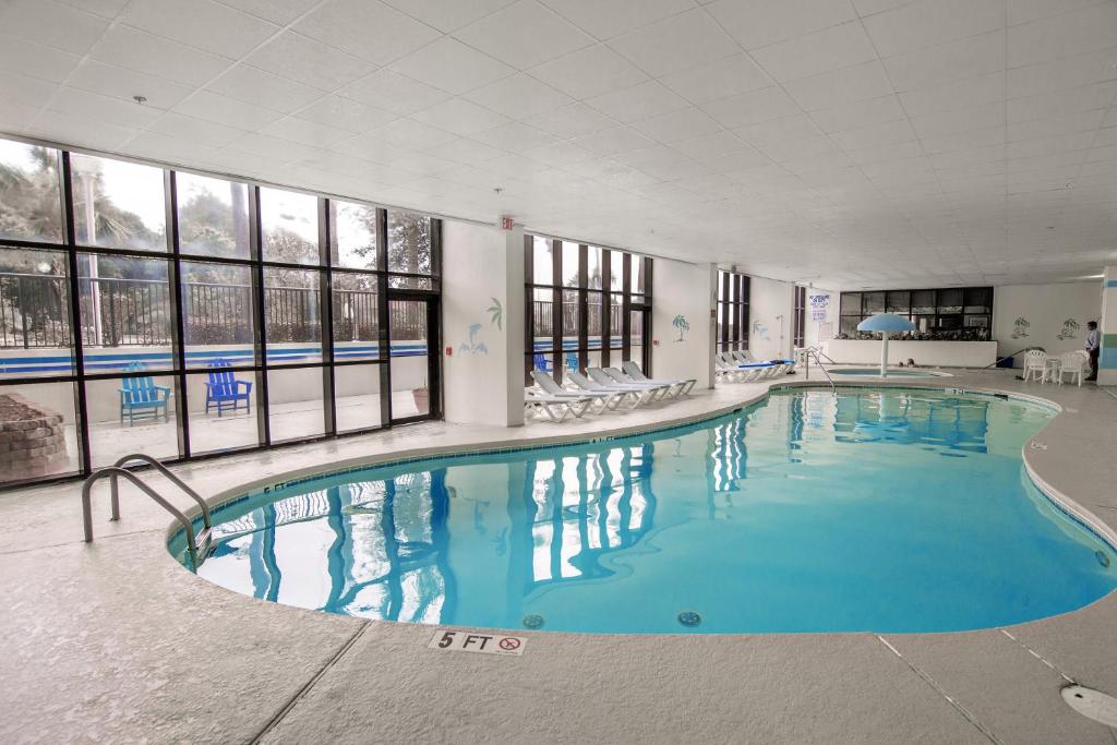 a large swimming pool with blue water in a building at Grande Shores in Myrtle Beach