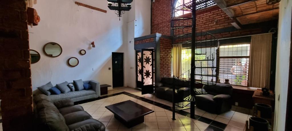 een woonkamer met een bank en stoelen in een gebouw bij Casa Tierra Mía in Tequila