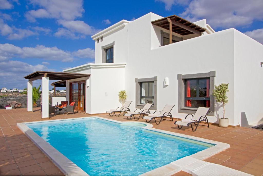 Villa con piscina frente a una casa en Villas Coral Deluxe, en Playa Blanca