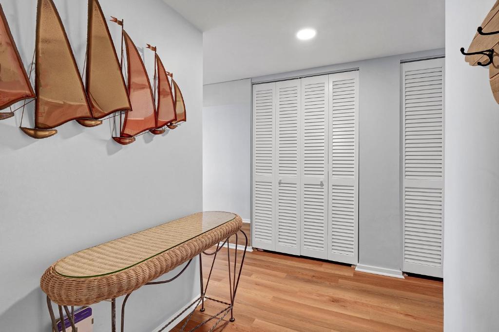 um camarim com um banco e pranchas de surfe na parede em The Islander - 9F by Sea Scape Properties em Wrightsville Beach