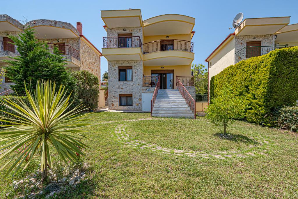 a large house with a yard in front of it at Holiday home with panoramic view of the forest in Polykhrono