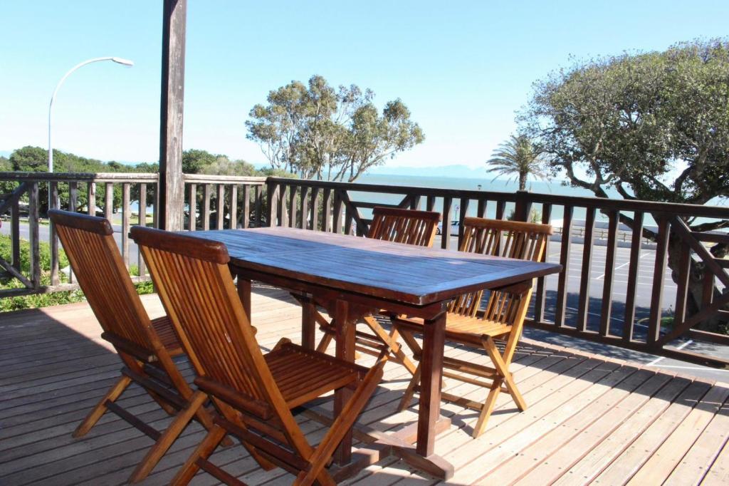 a wooden table and chairs on a deck at Sea and Mountain View Apartment in Cape Town