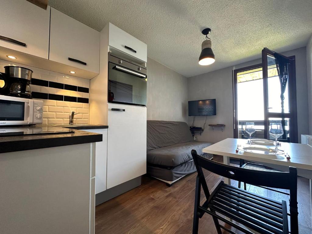 une cuisine et un salon avec une table et un canapé dans l'établissement Studio aux pieds des pistes, balcon, équipements modernes à Samoëns 1600 - FR-1-624-53, à Samoëns