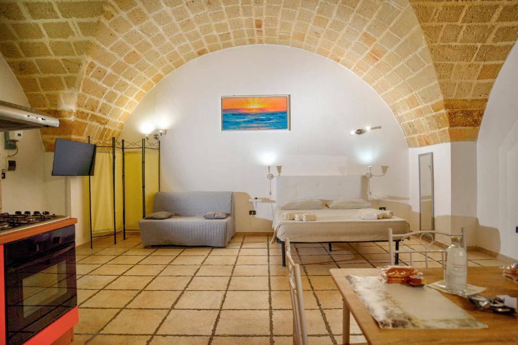 salon z kanapą i łóżkiem w pokoju w obiekcie History Station w mieście Brindisi