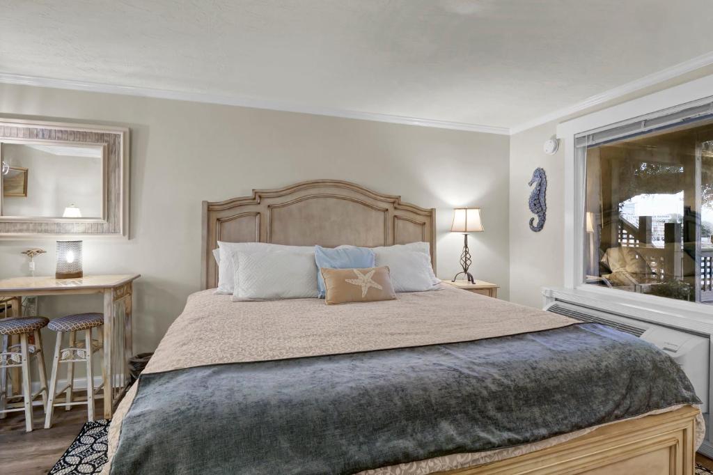 Un dormitorio con una cama grande y una ventana. en The Waterway 115 by Sea Scape Properties, en Wrightsville Beach