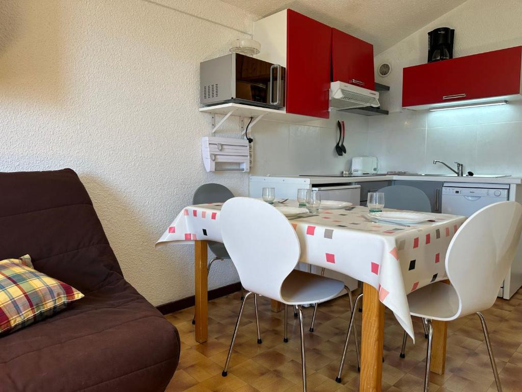 une cuisine avec une table et des chaises dans une pièce dans l'établissement Appartement familial au pied des pistes avec balcon à Samoëns 1600 - FR-1-624-79, à Samoëns