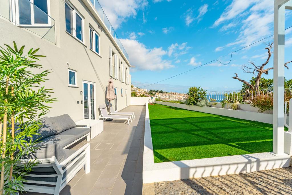 a patio with a lawn in the backyard of a house at JPL Blue Horizon Residential - D in Câmara de Lobos