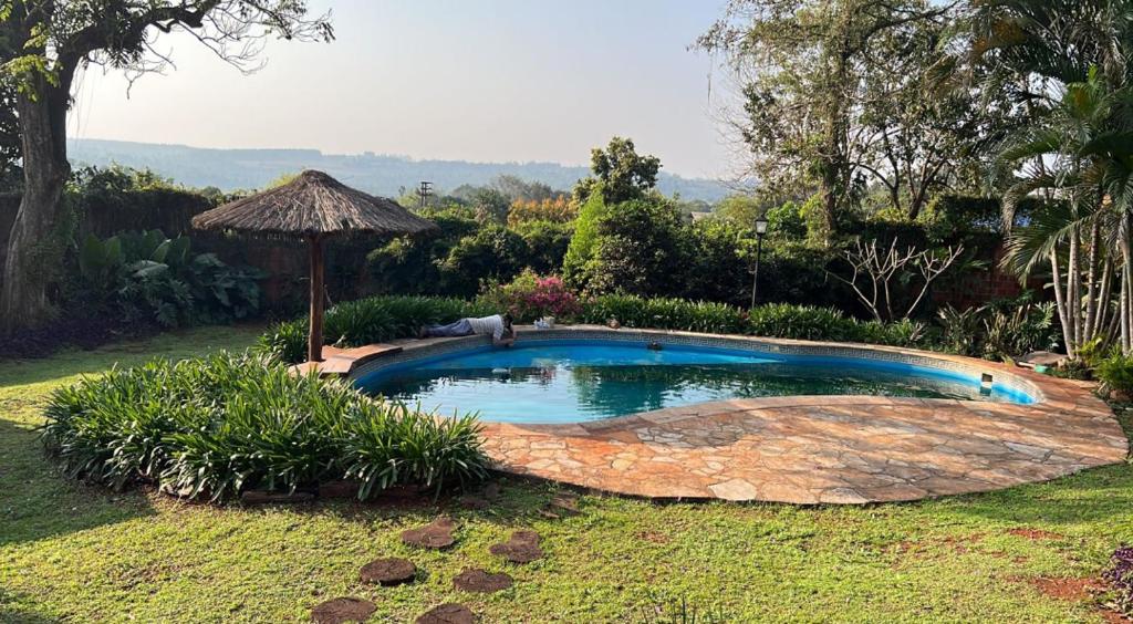 a small swimming pool in a yard with an umbrella at La casita de CristAl in Puerto Rico