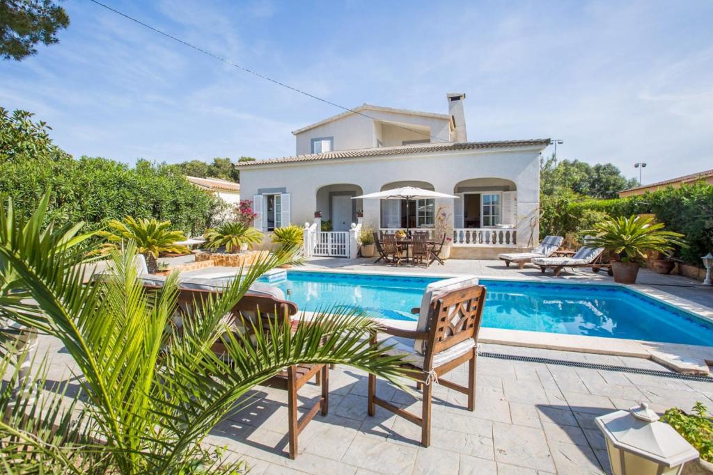 a villa with a swimming pool and a house at Can Navarro in Cala Pi