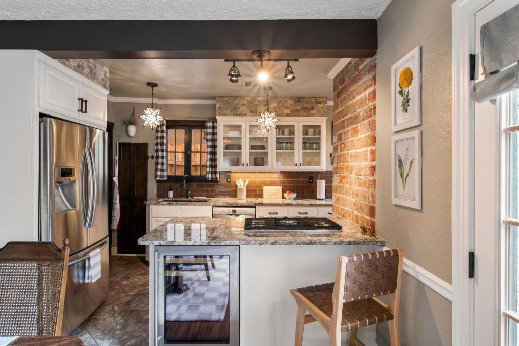 une cuisine avec des armoires blanches et un comptoir dans l'établissement Ivy Cottage W Hot Tub By Hvnlyhomes, à Tulsa