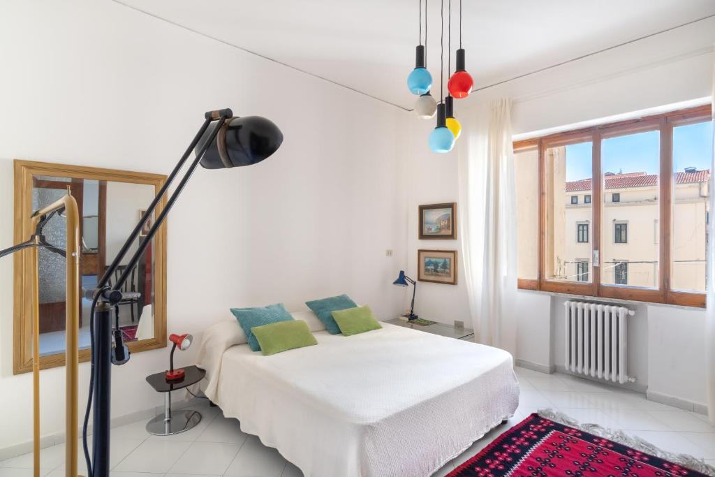 een witte slaapkamer met een bed en een raam bij Casa vacanza Angelina Via Mercanti Centro Storico in Salerno