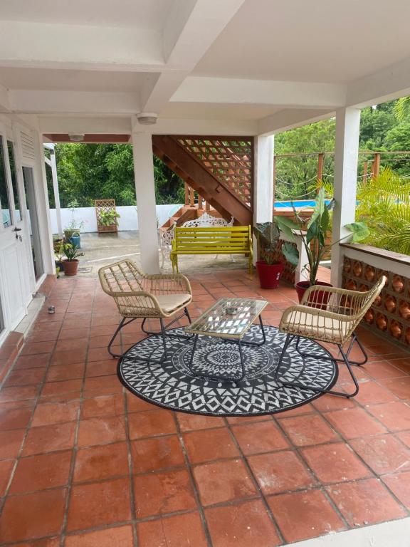 eine Terrasse mit 2 Stühlen und einem Tisch in der Unterkunft La Canopée - Appartement F2 avec piscine - vue mer in Le Robert