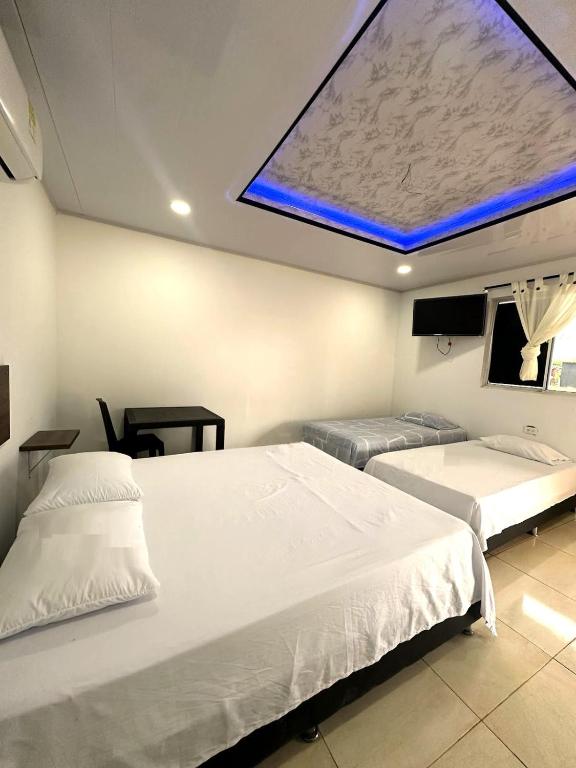 a hospital room with two beds and a large window at HOTEL y RESTAURANTE RANCHO GRANDE in Cicuco