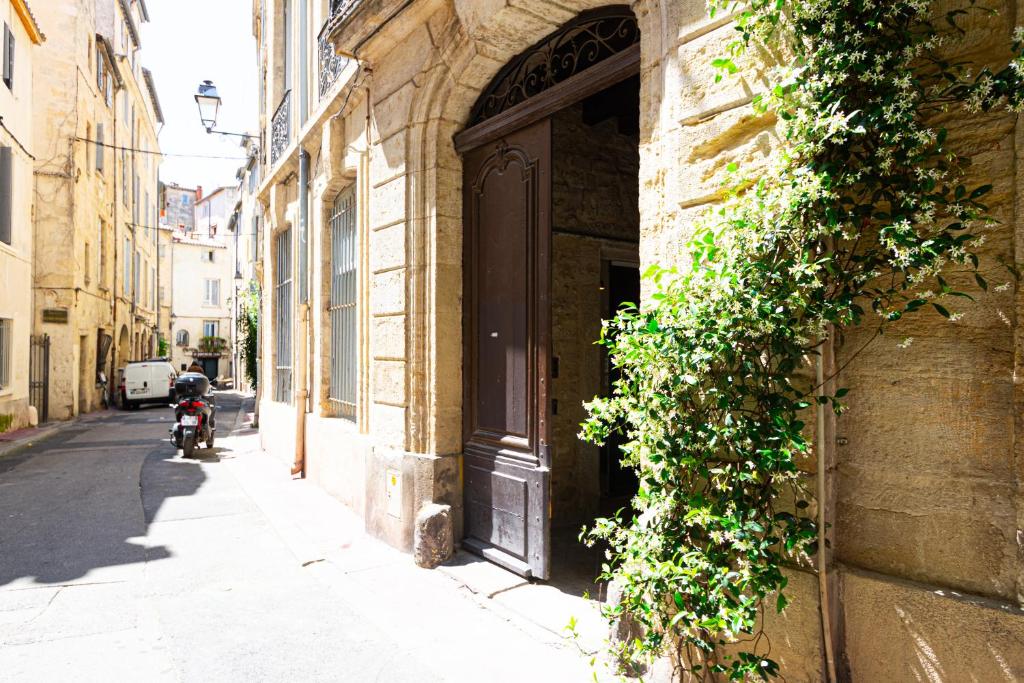 une porte menant à un immeuble avec une moto garée à côté de celui-ci dans l'établissement Cirrus Coeur Historique, à Montpellier