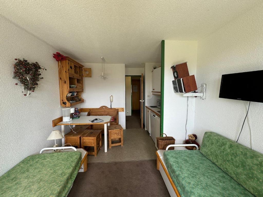 un salon avec deux canapés verts et une cuisine dans l'établissement Studio cosy avec balcon, accès direct aux pistes, Belle Plagne - FR-1-181-2222, à La Plagne Tarentaise