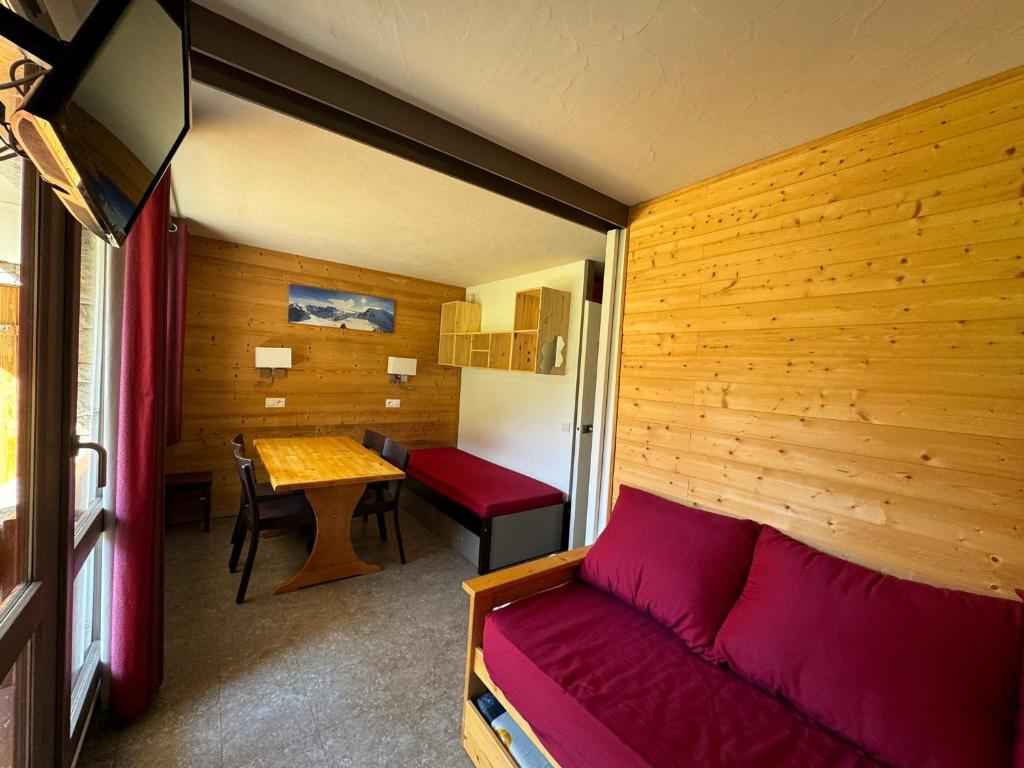 Cette petite chambre comprend un canapé et une table. dans l'établissement Studio Rénové au Cœur de la Station avec Balcon et Parking - FR-1-181-2431, à La Plagne Tarentaise