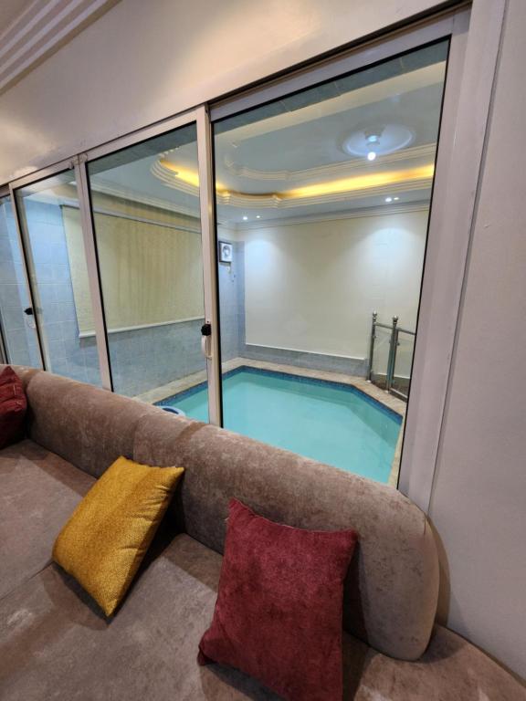 a swimming pool in a room with a couch at شقق قاردينيا in Aş Şafā