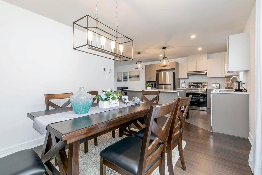 a kitchen and dining room with a table and chairs at City Oasis with Free Parking and Stylish Urban Gem in Longueuil
