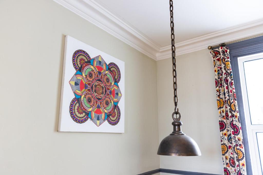 a pendant light hanging in a room with a painting at CloudZen in Kent