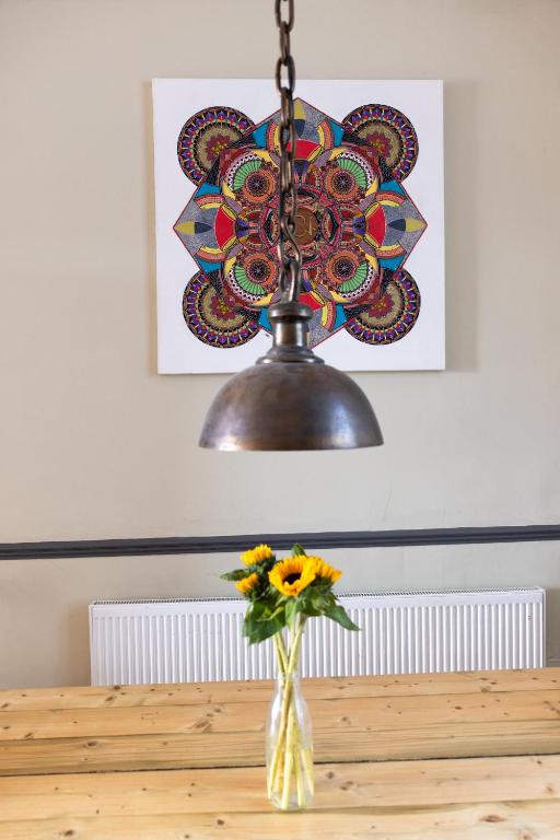 aendant light over a table with a vase of flowers at CloudZen in Kent