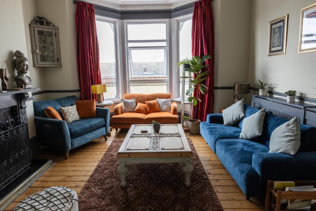 a living room with blue couches and a table at CloudZen in Kent