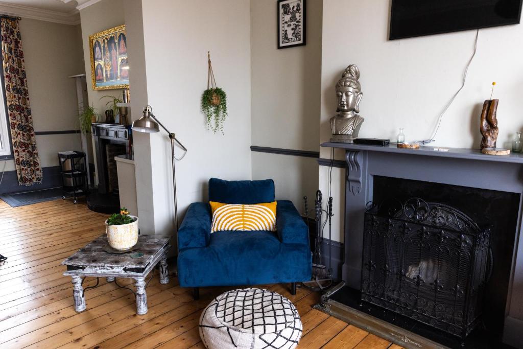 a living room with a blue chair and a fireplace at CloudZen in Kent