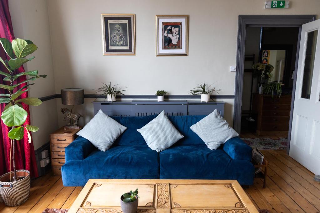a living room with a blue couch with pillows at CloudZen in Kent
