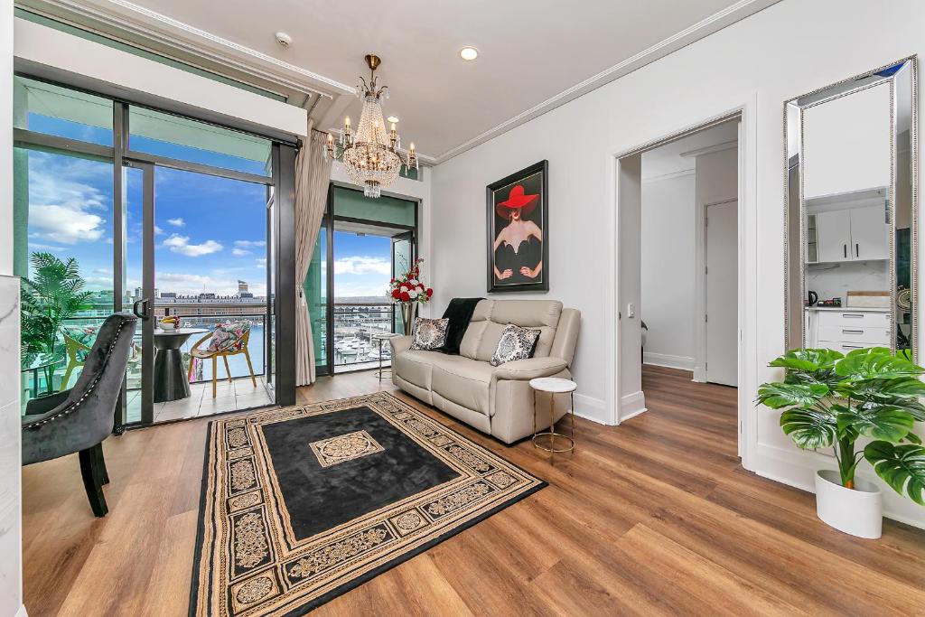 a living room with a couch and a floor to ceiling window at Penthouse Glory in Auckland