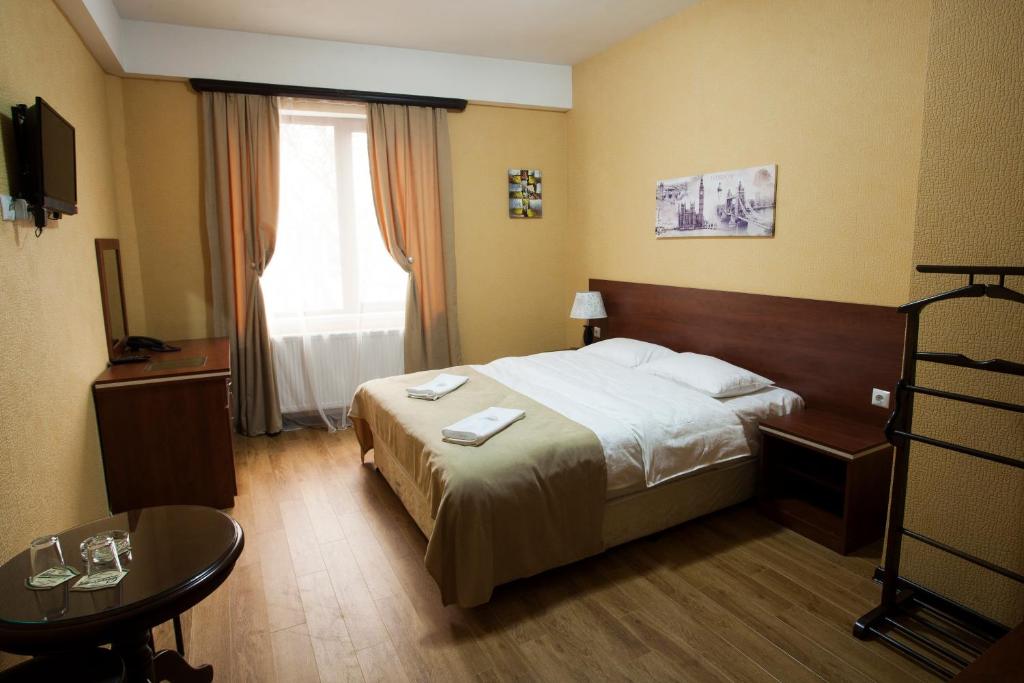 um quarto de hotel com uma cama e uma mesa em Lords Hotel em Tbilisi