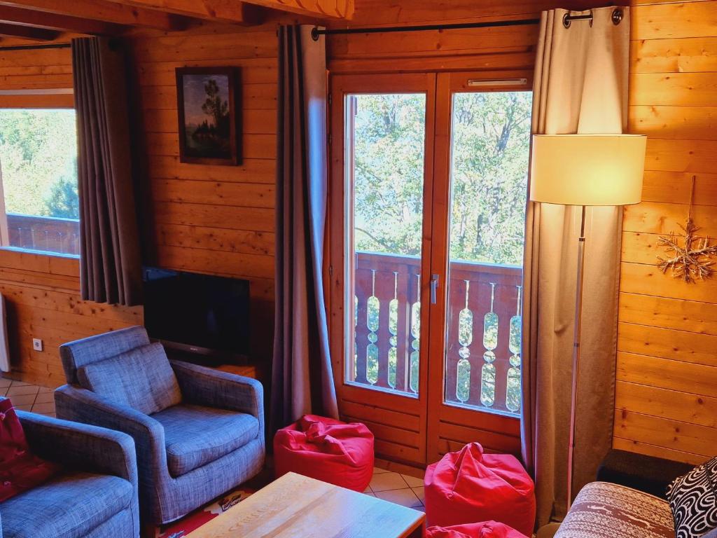un salon avec deux fauteuils et une télévision dans l'établissement Chalet à Montalbert: 3 Chambres, Mezzanine, Cheminée, Cuisine Équipée, Parking - FR-1-755-7, à Aime La Plagne
