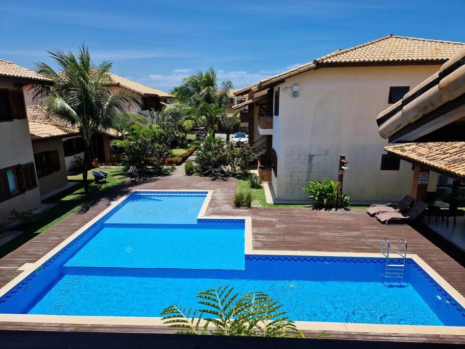 una grande piscina blu accanto a una casa di Apartamento tranquilo elegante espaçoso a Porto Seguro