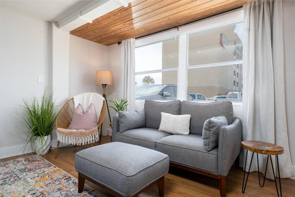 ein Wohnzimmer mit einer Couch und einem Sessel und einem Fenster in der Unterkunft Be A Nomad - Beach Cottage Oceanfront in Jacksonville Beach