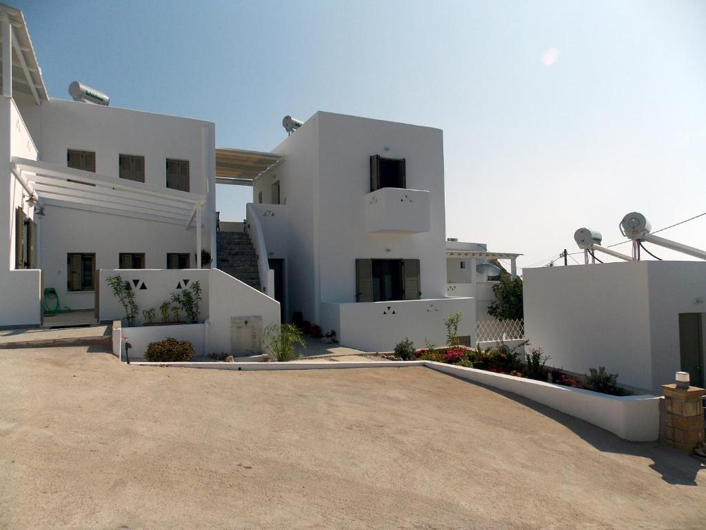 a large white house with a driveway in front of it at Aspous Studios and Rooms in Skiros