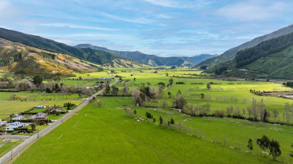 an aerial view of a green valley with mountains at Pukeko Cottage - Marlborough Sounds Retreat in Linkwater
