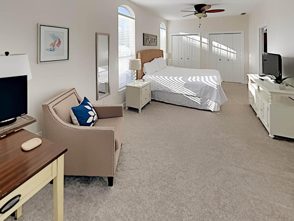 a bedroom with a bed and a desk and a tv at Changes In Latitude in Destin