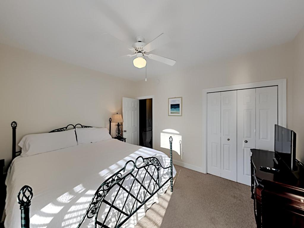 a white bedroom with a bed and a ceiling fan at Changes In Latitude in Destin